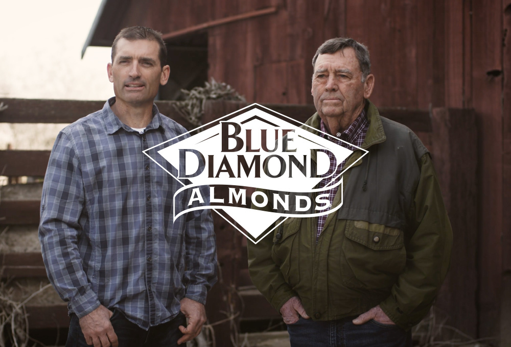 Blue Diamond Almonds logo over background of two growers in front of barn